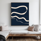 A modern living room with light wood sofas and beige cushions is elevated by the Blue Tranquility Abstract Canvas Art—featuring cream wavy lines on a dark blue background—displayed on a crisp white wall.