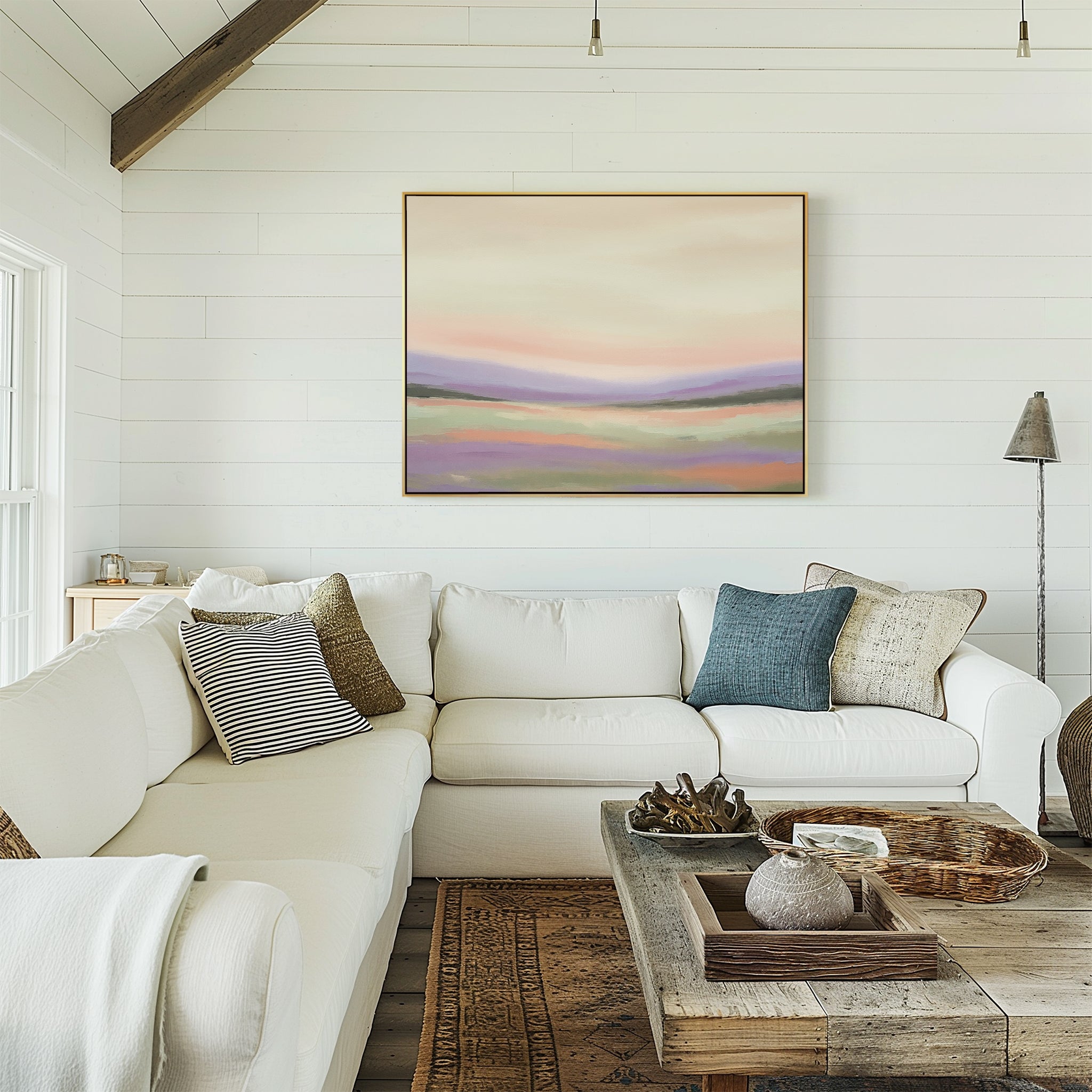 Bright, cozy living room with a white sectional sofa, neutral pillows, rustic wooden coffee table, and the Lavender Valley Canvas Art - Horizontal on the shiplap wall. Natural light streams in from large windows on the left.
