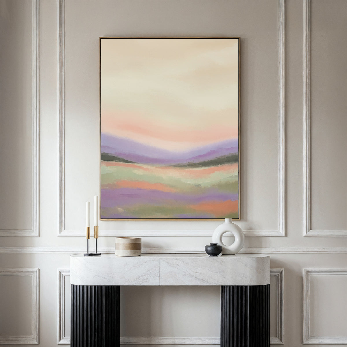 The Lavender Valley Canvas Art - Vertical, featuring soft pastel tones, hangs on a light gray wall above a marble console table adorned with candles, a round box, vase, and bowl, bringing tranquil Nordic charm to the space.