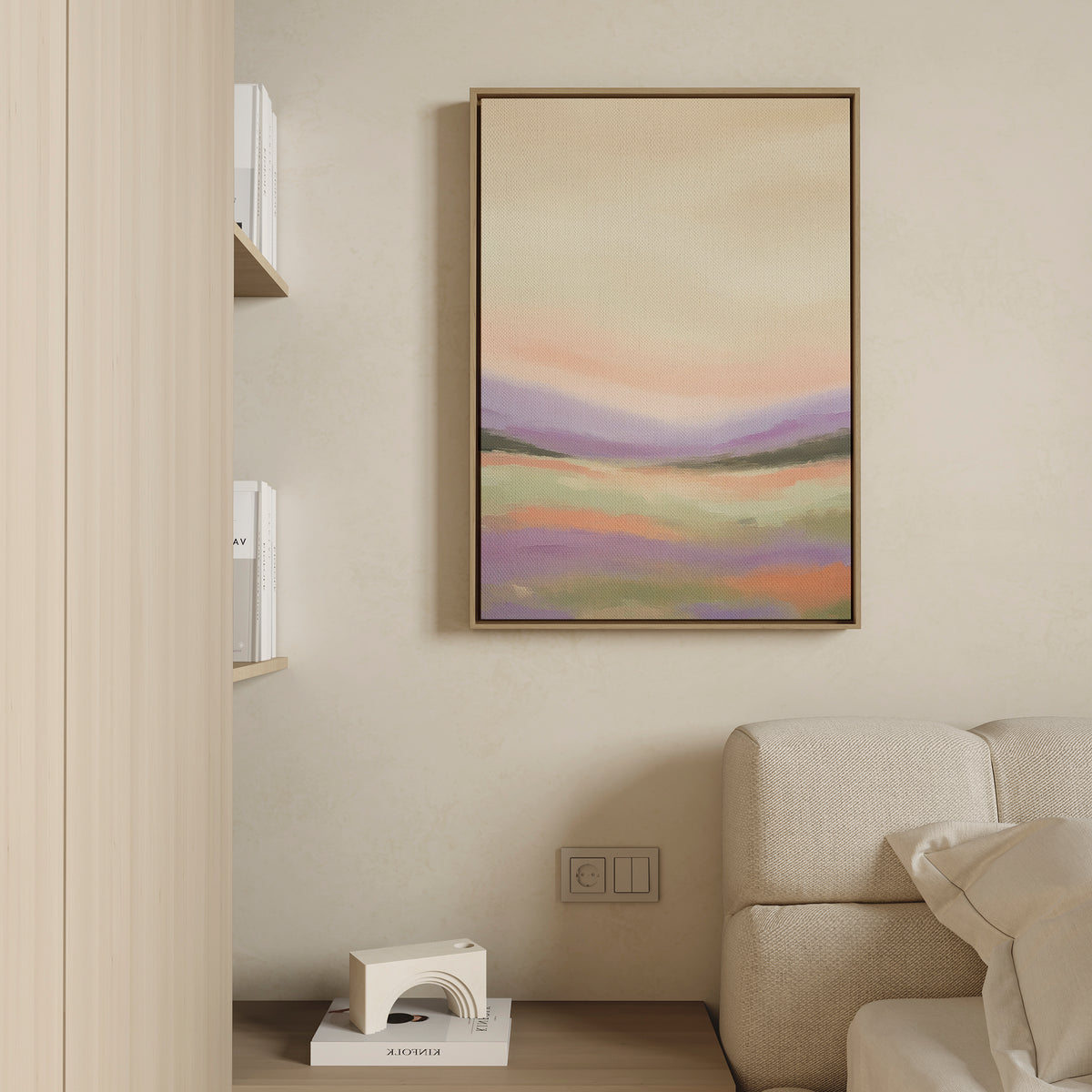 The Lavender Valley Canvas Art - Vertical hangs on a beige wall above a light-colored sofa. A wooden shelf with books and decor nearby completes the minimal look, enhancing the space with the soft, serene charm of lavender landscapes.