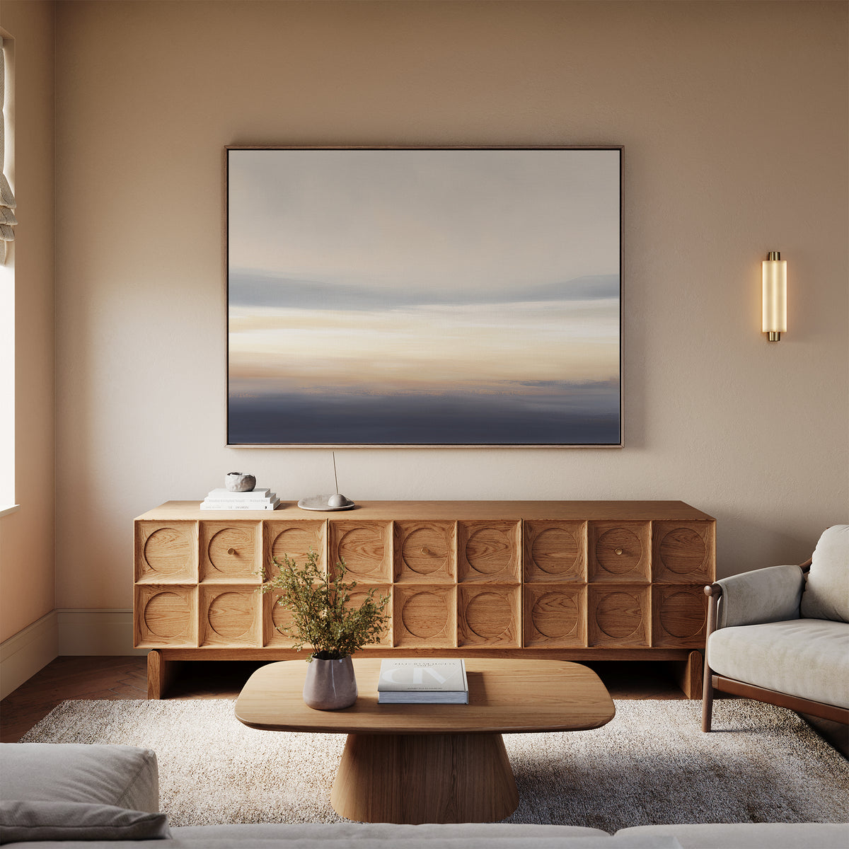 A modern living room displays a wooden sideboard, minimalist coffee table, light gray sofa, and a vase with flowers. Above the sideboard, Layered Dusk Canvas Art - Horizontal adds calming warmth with neutral abstract tones.