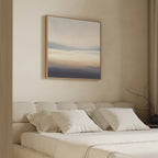 A softly lit bedroom features a beige upholstered bed with white pillows and bedding. Above hangs the Layered Dusk Canvas Art - Square, its neutral abstract tones adding Nordic Park tranquility beside floor-length curtains and a bare branch.
