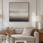 A modern living room with a beige sofa, neutral pillows, a side table with a ceramic lamp, dried flowers in a vase, and the calming Layered Dusk Canvas Art - Square hanging above the sofa.