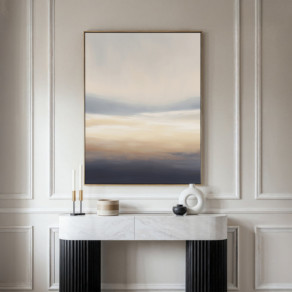 A minimalist hallway showcases a marble console table with black legs, candles, a round vase, and a lidded container. Above the paneled wall hangs the Layered Dusk Canvas Art - Vertical as striking abstract wall art.