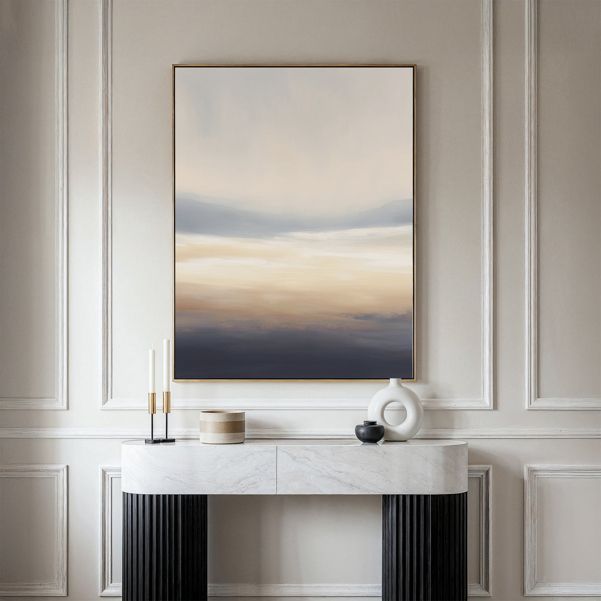 A minimalist hallway showcases a marble console table with black legs, candles, a round vase, and a lidded container. Above the paneled wall hangs the Layered Dusk Canvas Art - Vertical as striking abstract wall art.