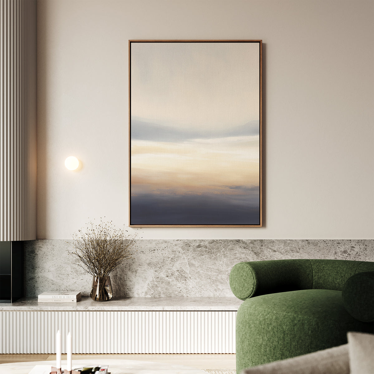 A modern living room features the Layered Dusk Canvas Art - Vertical as wall art, a round green sofa, stone bench, dried branch vase, and minimal decor in a neutral-toned setting.