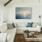 A bright, airy living room with white shiplap walls, a large white sectional sofa, blue and neutral throw pillows, a rustic wooden coffee table, and the Luminous Calm Canvas Art - Horizontal evoking ocean sunset tranquility.