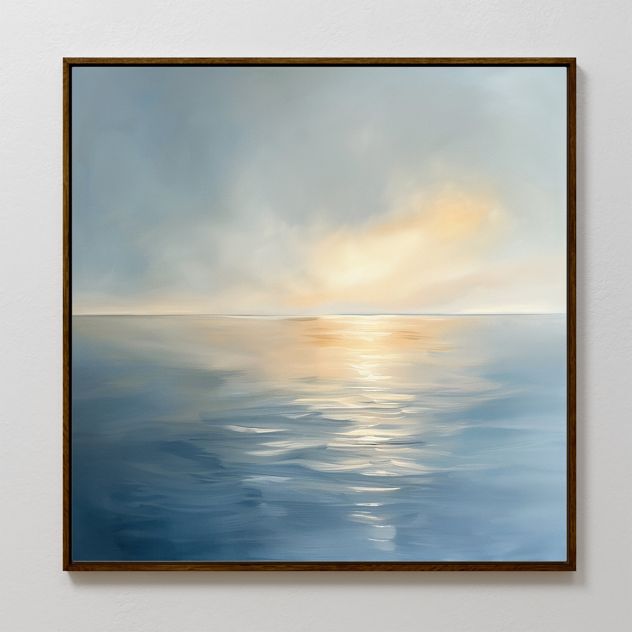 The Luminous Calm Canvas Art - Square features a serene seascape with soft blue water and golden-orange hues, capturing sunlight breaking through clouds at sunrise or sunset. This framed print brings tranquil coastal beauty to your space.