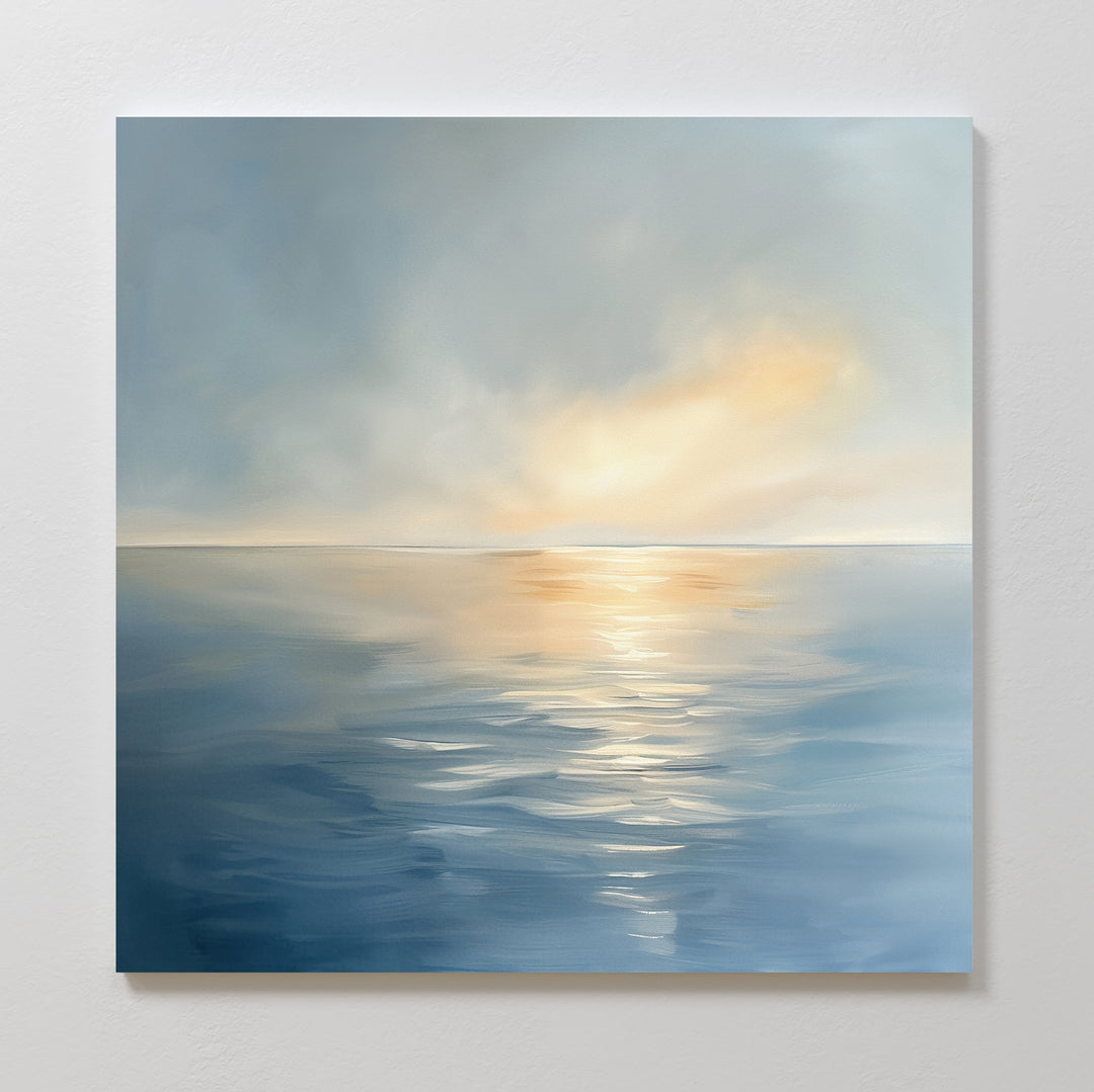 The Luminous Calm Canvas Art - Square features a serene coastal palette, soft sunrise or sunset light reflecting on calm ocean waters, and gentle clouds above, creating a peaceful and tranquil atmosphere for any space.