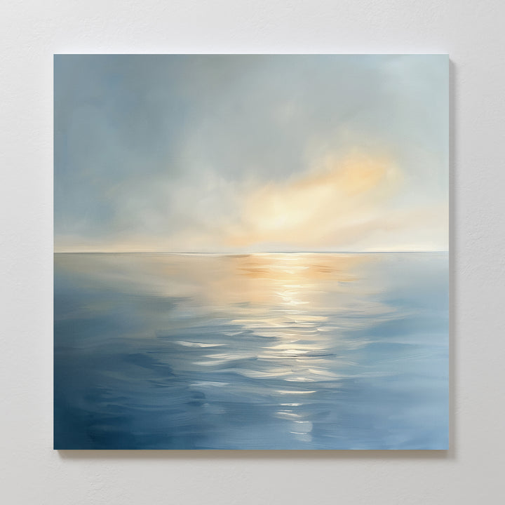 The Luminous Calm Canvas Art - Square features a serene coastal palette, soft sunrise or sunset light reflecting on calm ocean waters, and gentle clouds above, creating a peaceful and tranquil atmosphere for any space.