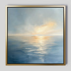 The Luminous Calm Canvas Art - Square features a tranquil sea beneath a cloudy sky, with soft sunlight on the water and a soothing palette of blues, grays, and golds to create a serene, peaceful atmosphere.