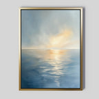 The Luminous Calm Canvas Art - Vertical, showcasing serene blue waters and golden sunset hues beneath a cloudy sky, brings soothing coastal elegance to a light gray wall.