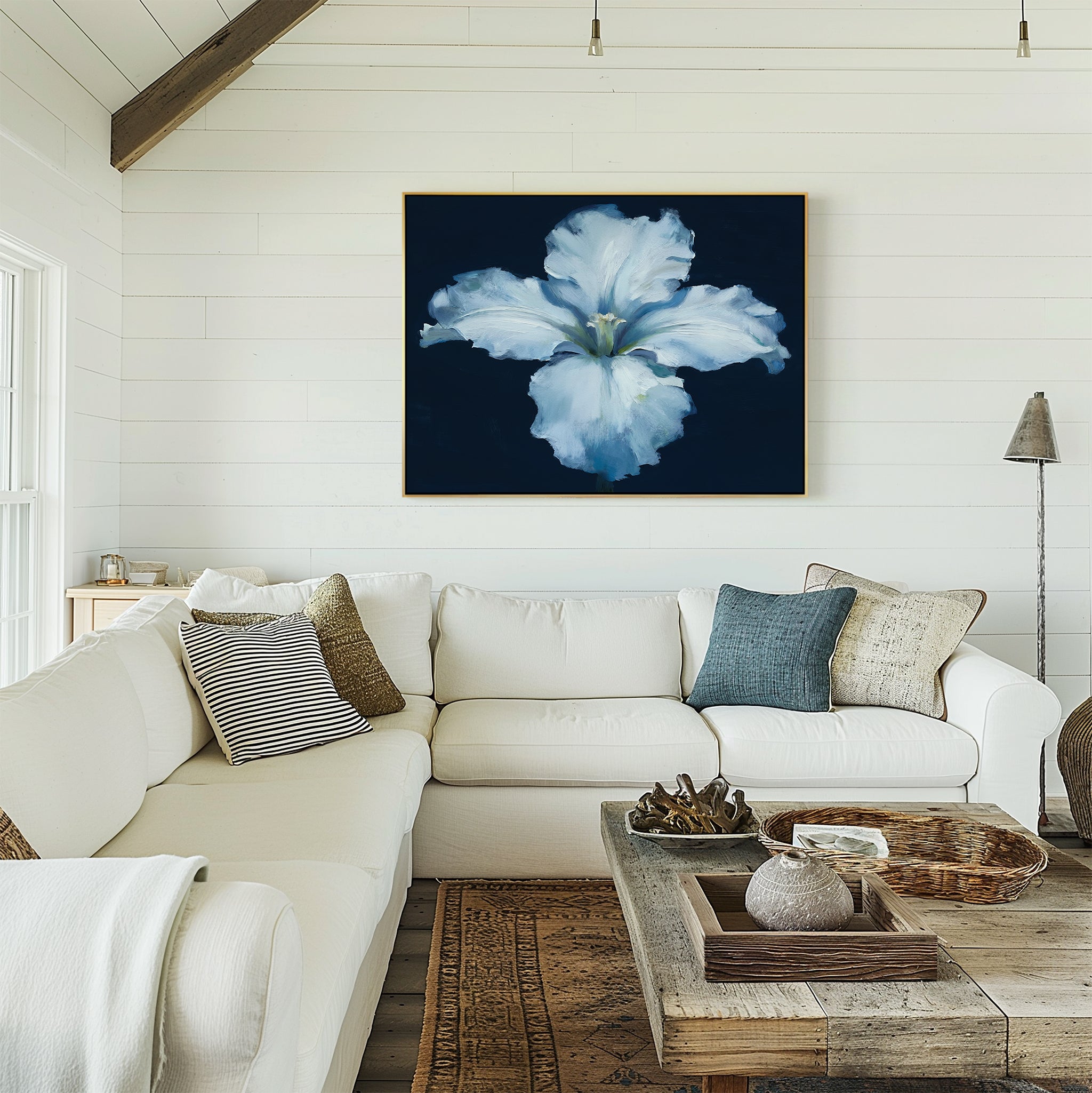 A cozy living room features a white sectional, neutral pillows, rustic wood coffee table, and the Luminous Iris Canvas Art - Horizontal on a white shiplap wall. Natural light streams in from the left window.