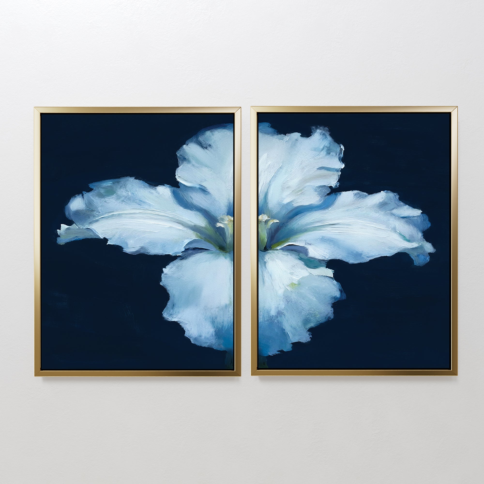 The "Luminous Iris - Set of 2" features diptych wall art with soft blue iris petals on a dark blue backdrop, split across two gold-framed canvases to create a serene Nordic vibe, perfect for display on a white wall.