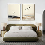 A modern bedroom with a green upholstered bed, white bedding, two gold bedside tables with beige lamps, and the Maritime Flight - Set Of 2 prints featuring abstract birds and landscapes above the bed.