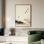A modern living room with a green sofa and coastal decor showcases a built-in bench with marble detail. Above, the Maritime Flight Canvas Art - Vertical hangs, depicting an abstract seascape with four birds in flight. A vase with dried branches sits nearby.
