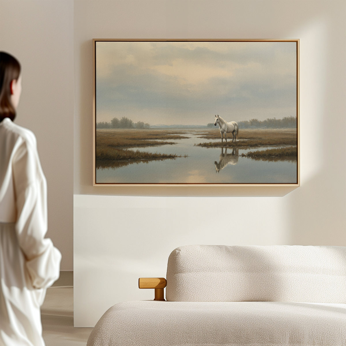 A person stands in a softly lit room, admiring the Marsh Reflection Canvas Art - Horizontal. The tranquil landscape adds serenity, while a beige sofa in the foreground brings warmth to the peaceful scene.