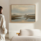 A person stands in a softly lit room, admiring the Marsh Reflection Canvas Art - Horizontal. The tranquil landscape adds serenity, while a beige sofa in the foreground brings warmth to the peaceful scene.