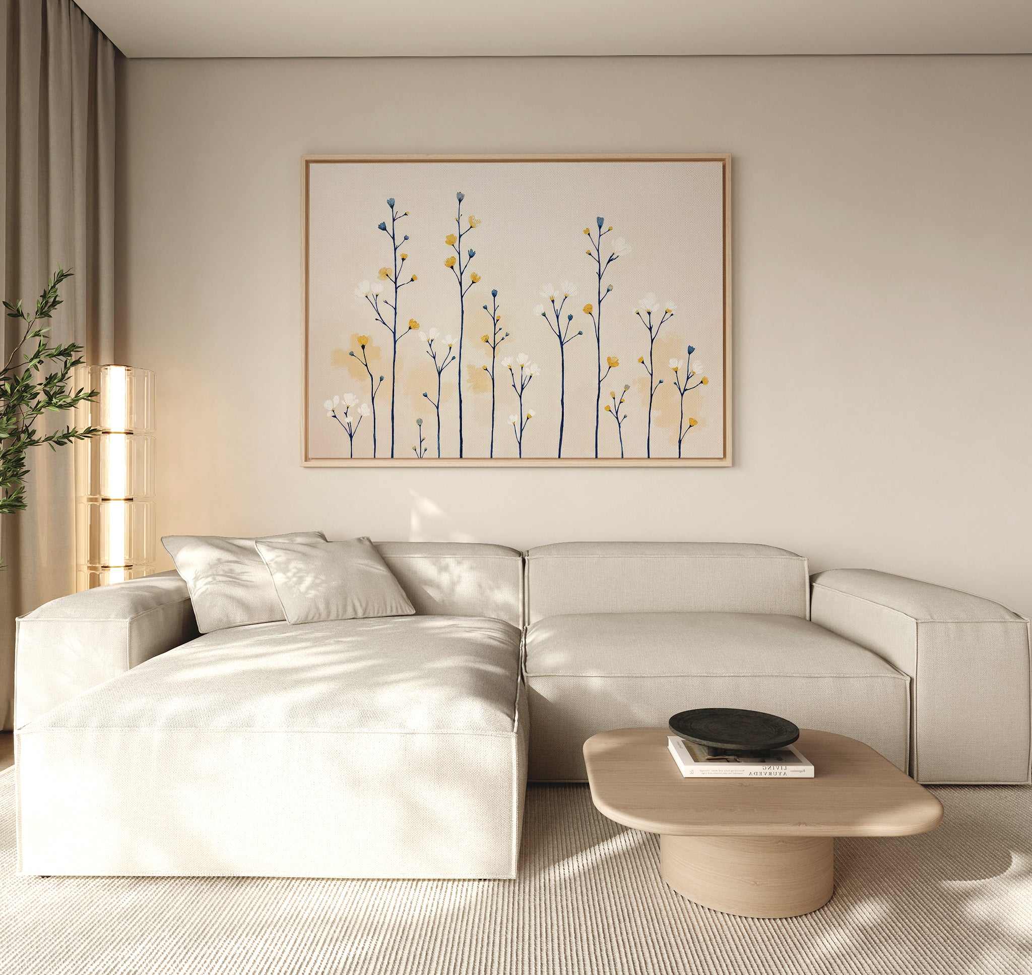 A modern living room features a light beige sectional, a low wooden coffee table, and the Meadow Symphony Canvas Art - Horizontal on the wall with minimalist blue and yellow flowers. Neutral tones and natural lighting add to the serene atmosphere.