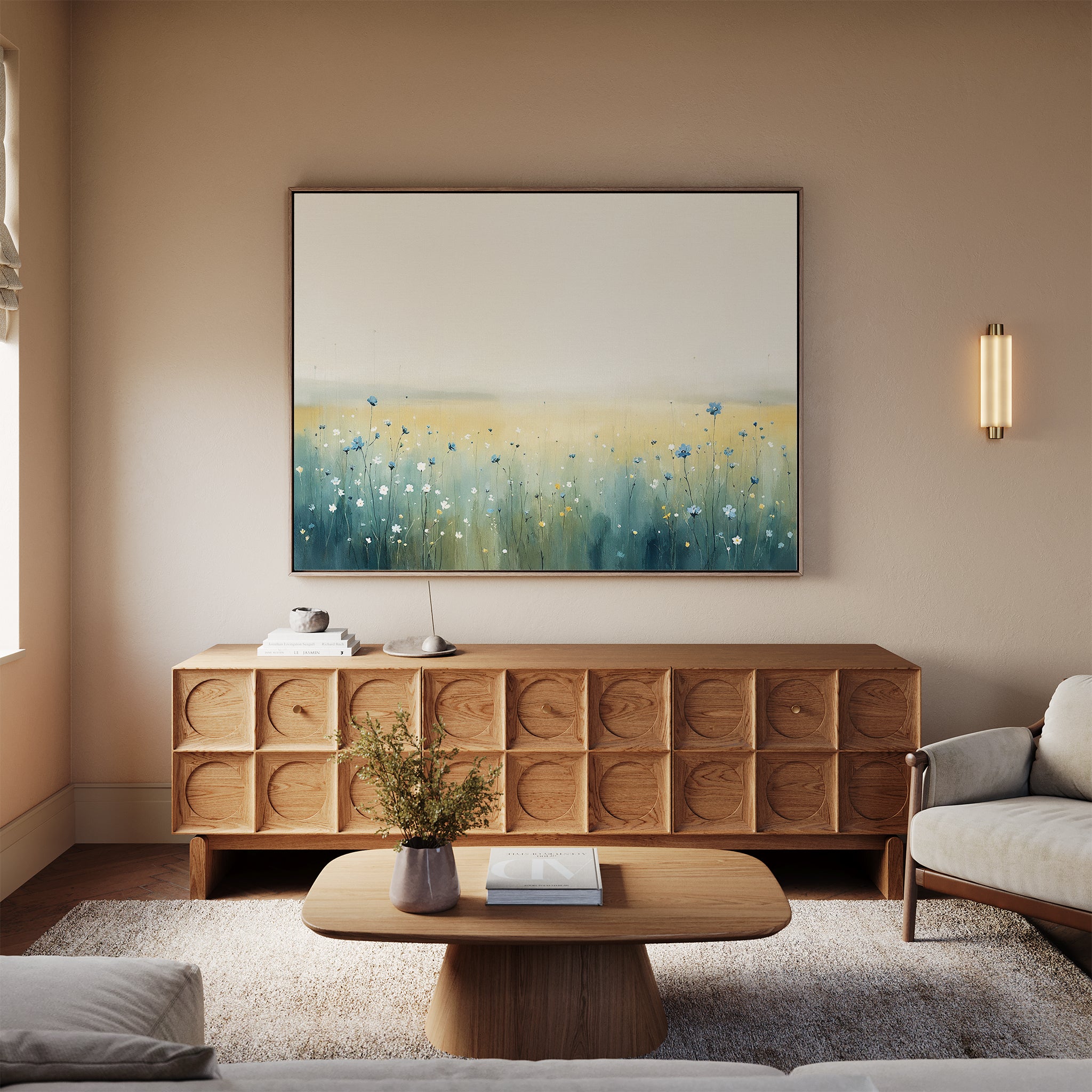 A cozy living room featuring a light wood sideboard, modern coffee table, beige sofa, and the Meadow Whispers Canvas Art - Horizontal depicting an impressionistic wildflower landscape above the sideboard, with a lamp and vase for accents.