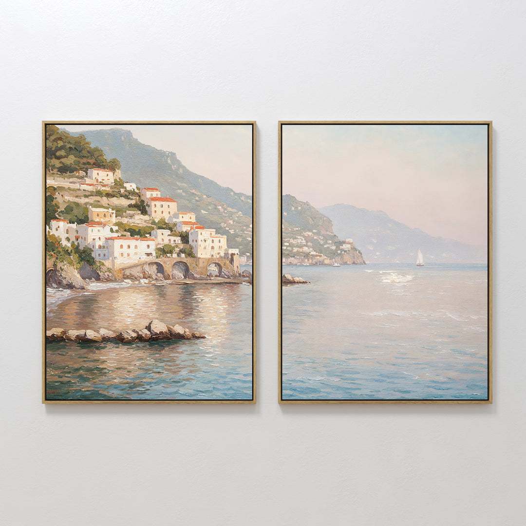 Mediterranean Dreams - Set of 2 features framed paintings of a coastal village with colorful cliffside houses, calm blue sea, mountains, and a sailboat—ideal wall art for serene home decor.