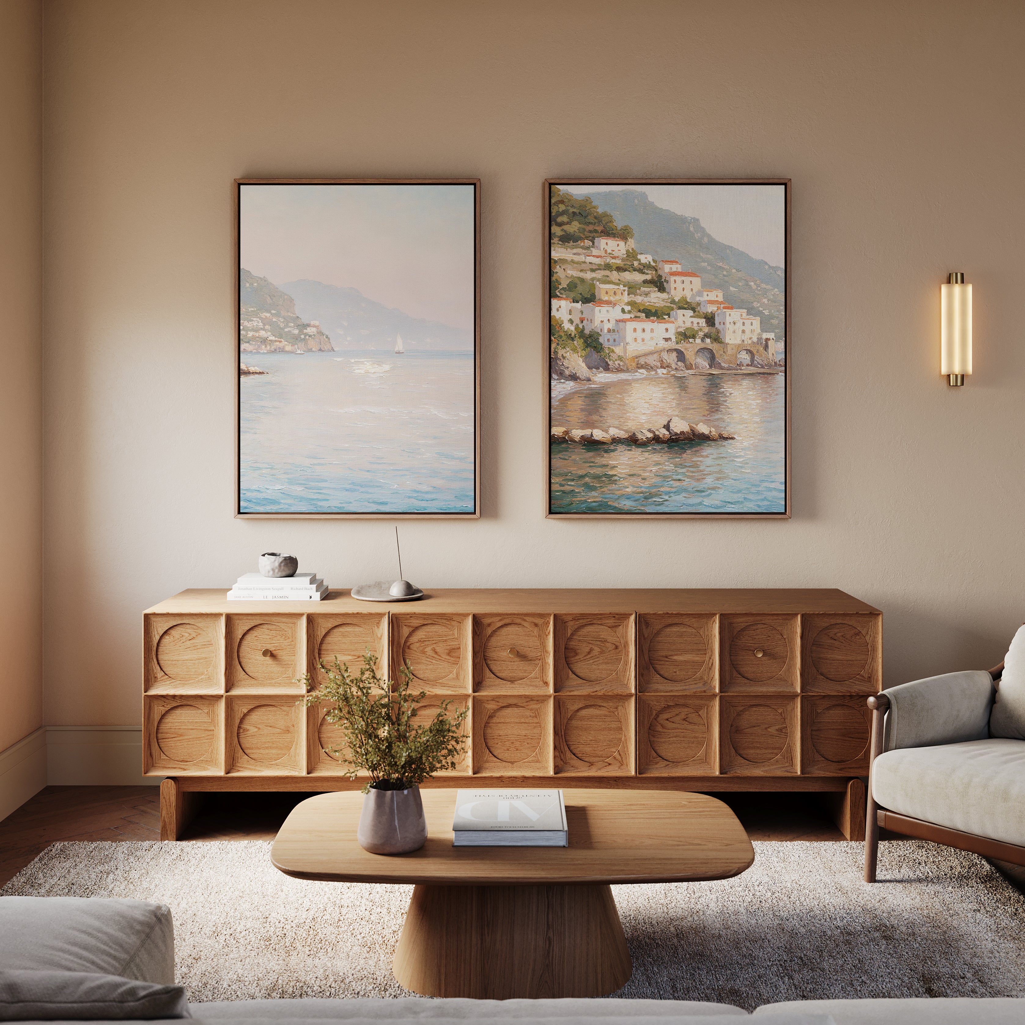 A cozy living room featuring the Mediterranean Dreams - Set of 2 wall art, a wooden sideboard, round coffee table with vase and book, light armchair, and textured rug for a serene home decor look.