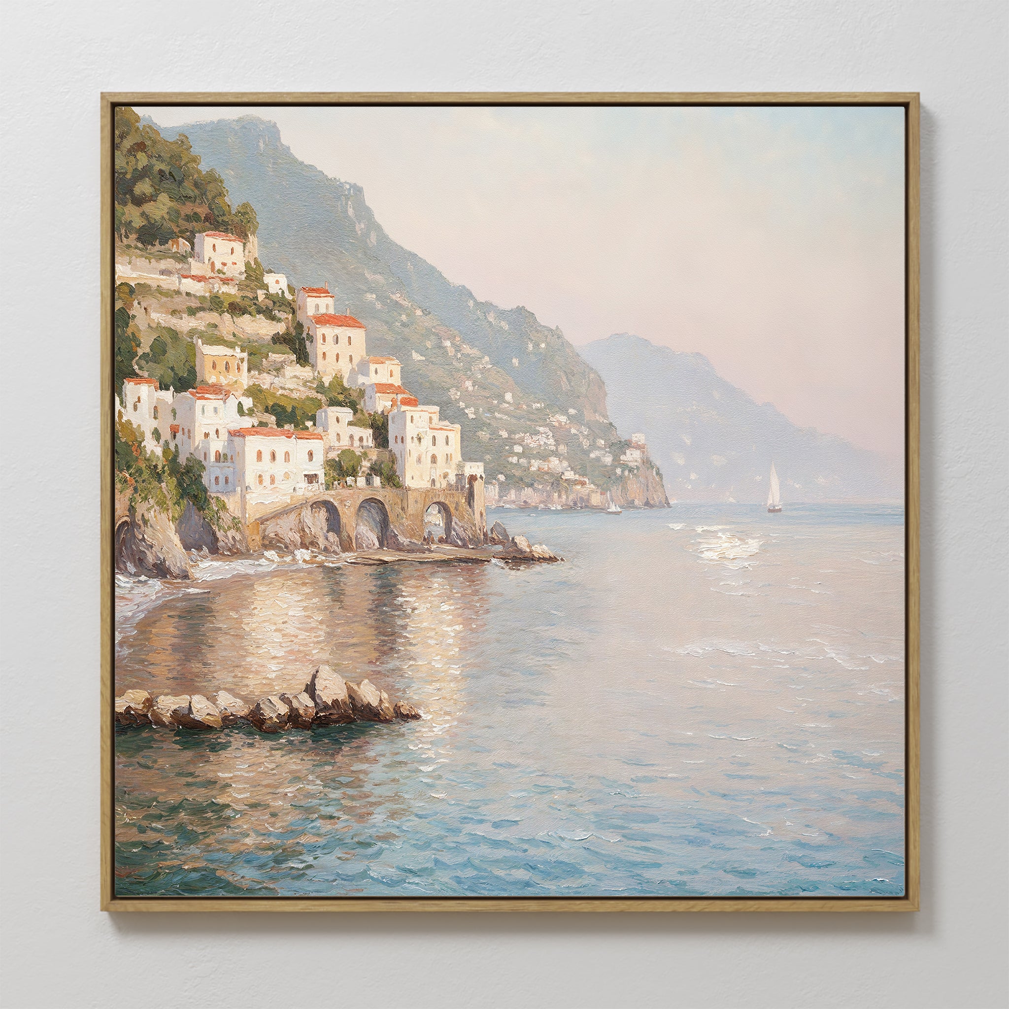 The "Mediterranean Dreams Canvas Art - Square" features a coastal village with white and pastel hillside houses, a sailboat on calm blue water, and sunlight reflecting on the sea—beautifully framed for your wall.