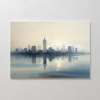 The Metropolitan Dawn Canvas Art - Horizontal depicts a serene city skyline at sunrise or dusk, with tall buildings mirrored in calm waters beneath a hazy blue and beige sky.