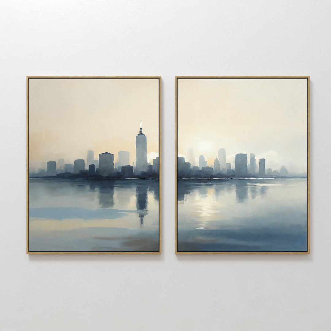 Metropolitan Dawn - Set of 2 features framed paintings of a city skyline reflected in water. Soft blue and beige tones create a calm, misty ambiance, with the split canvases forming one continuous scene of urban serenity.