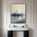 A modern entryway features a marble console table with minimalist decor beneath the Metropolitan Dawn Canvas Art - Vertical, showcasing a soft city skyline, all set against elegant paneled walls.