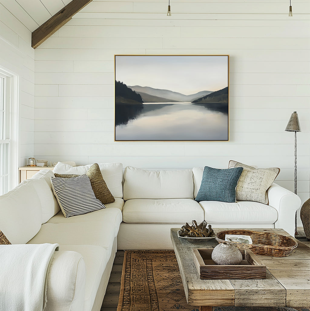 A cozy living room with a white sectional sofa, assorted pillows, a rustic wooden coffee table, and the Mirror Valley Canvas Art - Horizontal in calming natural hues hanging on a white shiplap wall.