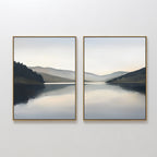 The "Mirror Valley - Set of 2" features framed canvas prints showcasing a tranquil lake, distant hills, and a cloudy sky in muted blues, grays, and greens for a serene Nordic Park vibe.