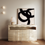 A minimalist sideboard with a wavy edge displays a lamp, two candles, and the Monochrome Stream Abstract Canvas Art. Two round wall lights and sheer curtains accentuate the modern, neutral-toned living room decor.