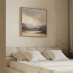 A minimalist bedroom with a beige upholstered bed, white bedding, and neutral pillows. Above the bed hangs the Mountain Reverie Canvas Art - Square. Simple curtains and a bare branch add to this tranquil space.