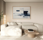 A modern living room features a cream sectional sofa, light wood coffee table, and the Navy Brushwork Canvas Art - Horizontal above. A tall plant in the corner and ample natural light complete the inviting space.