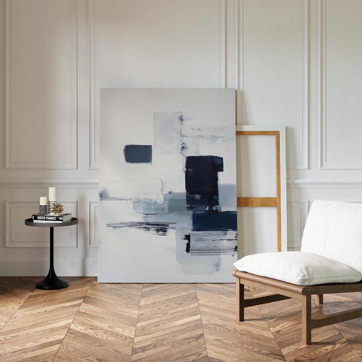 A minimalist room with herringbone wood floors features the Navy Brushwork Canvas Art - Vertical leaning against a white paneled wall, next to a modern chair and small black side table—a perfect accent for minimalist home decor.