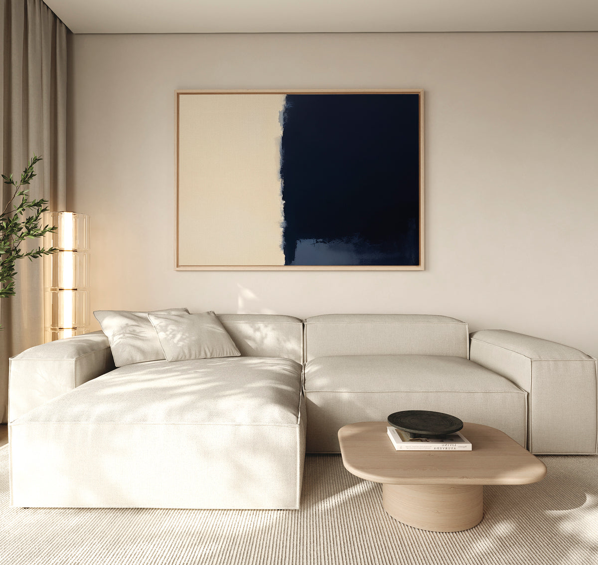 A modern living room features a cream sectional sofa, light wood coffee table, and the Navy Division Canvas Art - Horizontal in navy and beige on the wall. Natural light and a corner plant add to the room's elegant, airy feel.