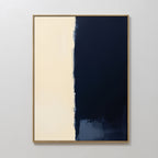 The Navy Division Canvas Art - Vertical features two halves: a textured creamy beige on the left and deep navy blue on the right with an uneven border. A simple, light frame adds modern elegance to this minimalist artwork.