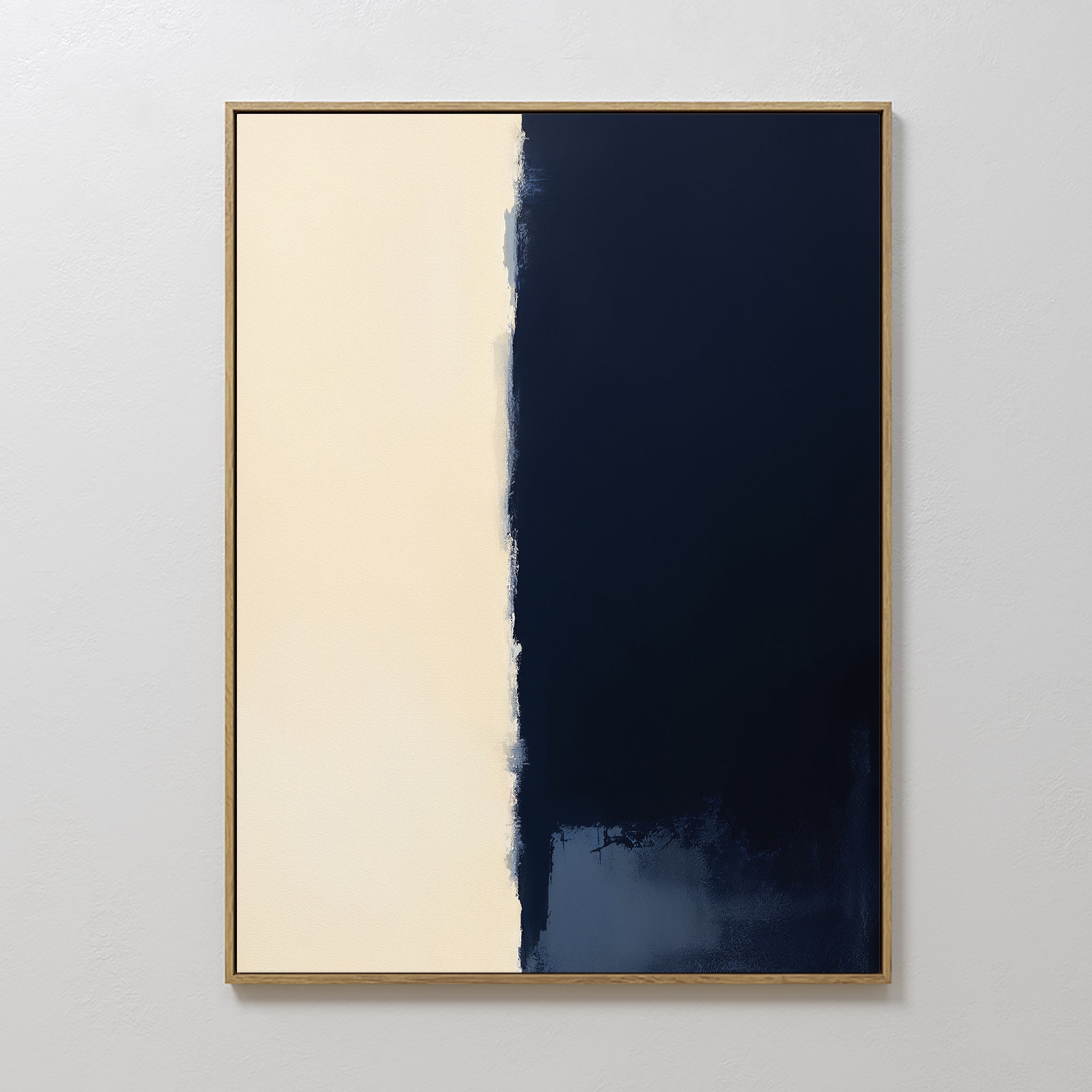 The Navy Division Canvas Art - Vertical features two halves: a textured creamy beige on the left and deep navy blue on the right with an uneven border. A simple, light frame adds modern elegance to this minimalist artwork.