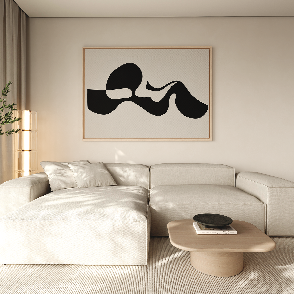 A modern living room with a light beige sectional, neutral cushions, a round wooden coffee table, sheer curtains, and the Fluid Forms Abstract Canvas Art in striking black and white displayed on the wall.