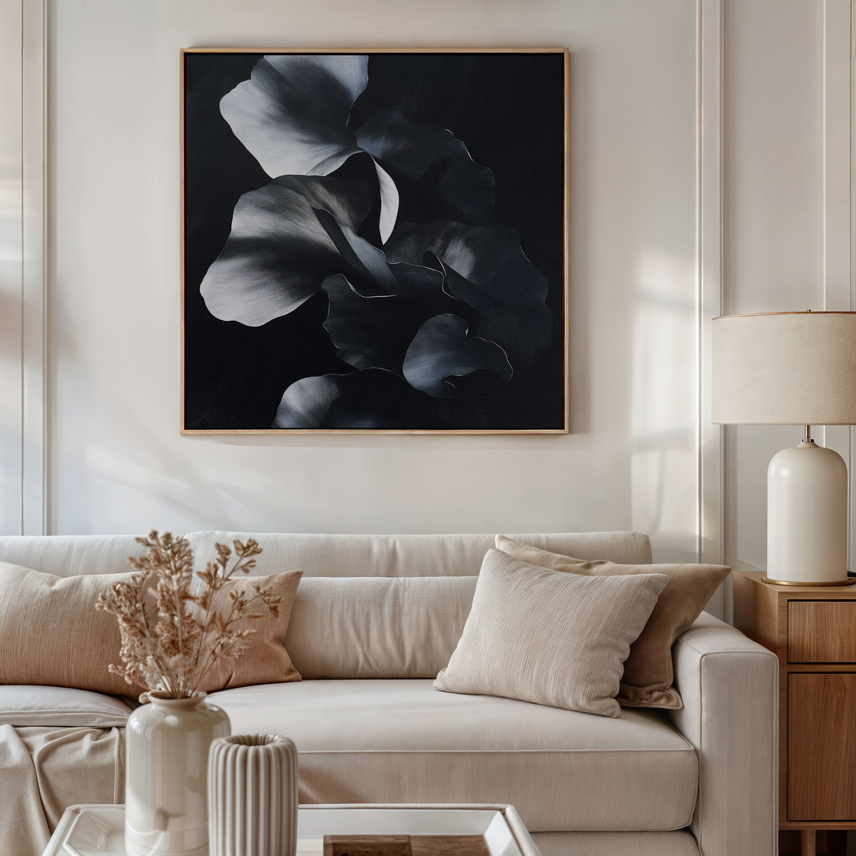 A stylish living room features a beige sofa with neutral cushions, a matching lamp and side table, dried flowers in a vase, and the Nocturnal Bloom Abstract Canvas Art displayed above the sofa.