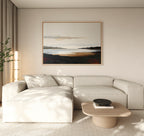 A modern living room featuring a light beige sectional sofa, round wooden coffee table with a black bowl, tall plant, and the Nordic Waters Canvas Art - Horizontal above the sofa. Neutral tones and natural light complete the scene.