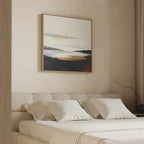 A minimalist bedroom features a beige bed, white pillows, and neutral walls. Above the bed hangs the Nordic Waters Canvas Art - Square, a calming abstract in soft earth tones. A bare branch on the nightstand completes the sophisticated decor.