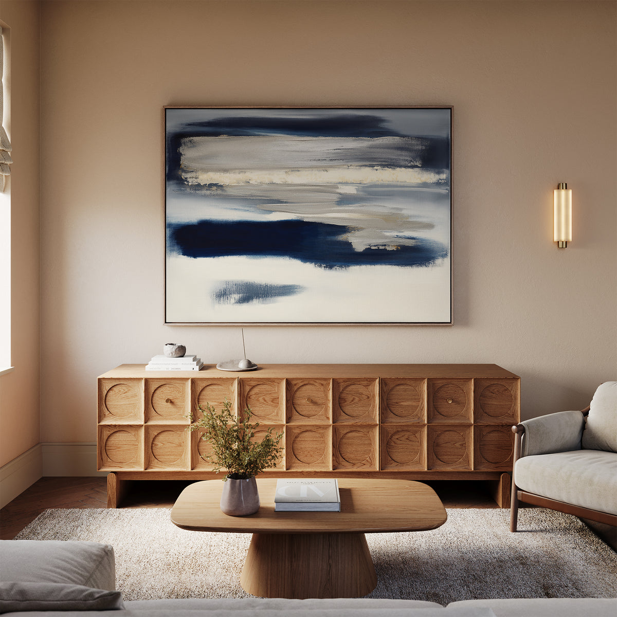A cozy living room featuring a modern wooden sideboard, a beige sofa, a textured rug, and the Northern Tides Canvas Art - Horizontal in calming blue and white tones above the sideboard, styled in a minimalist palette.