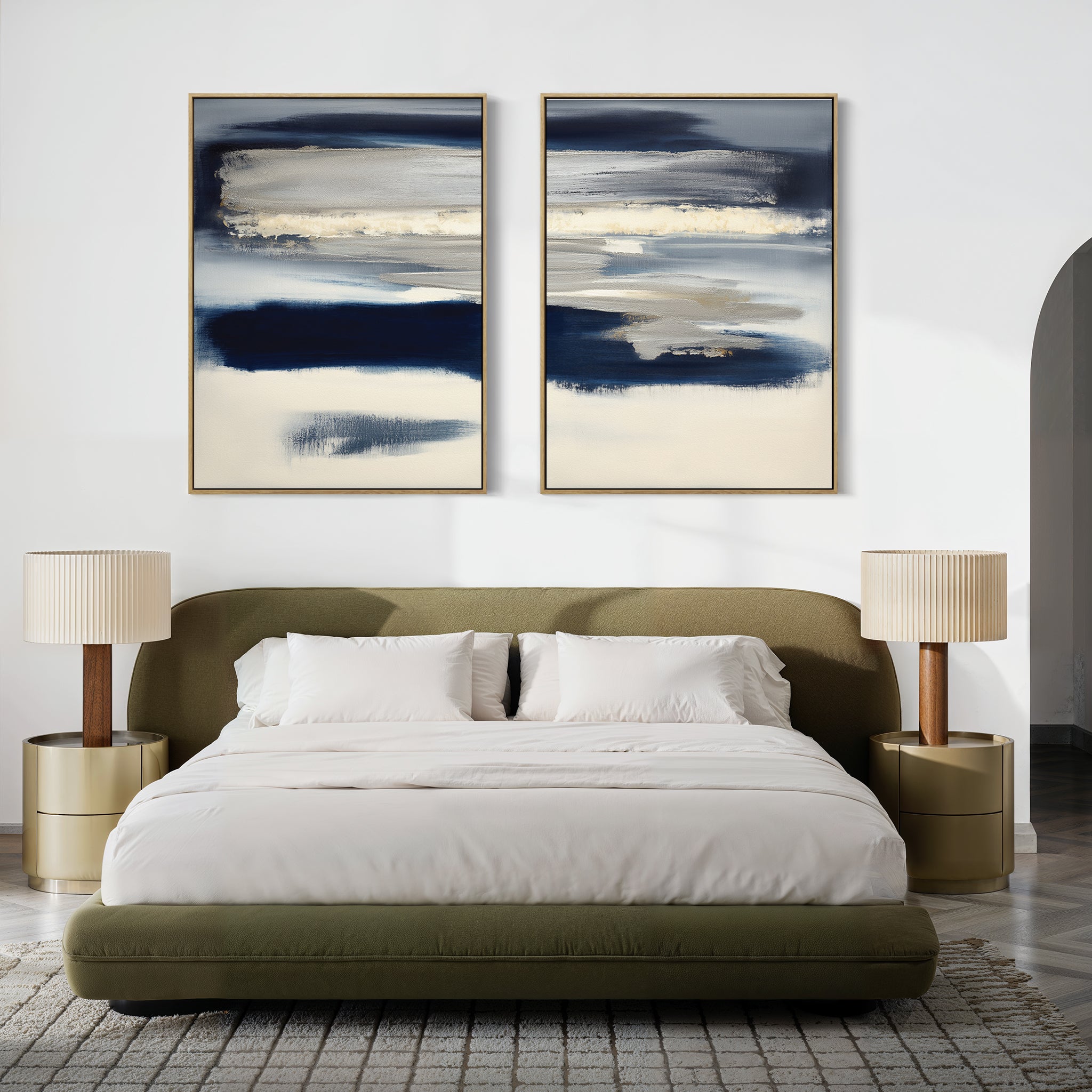 A modern bedroom features a green upholstered bed with white bedding, two beige nightstands with matching lamps, and "Northern Tides - Set Of 2" artwork above the bed. A textured rug in a minimalist palette covers the floor.