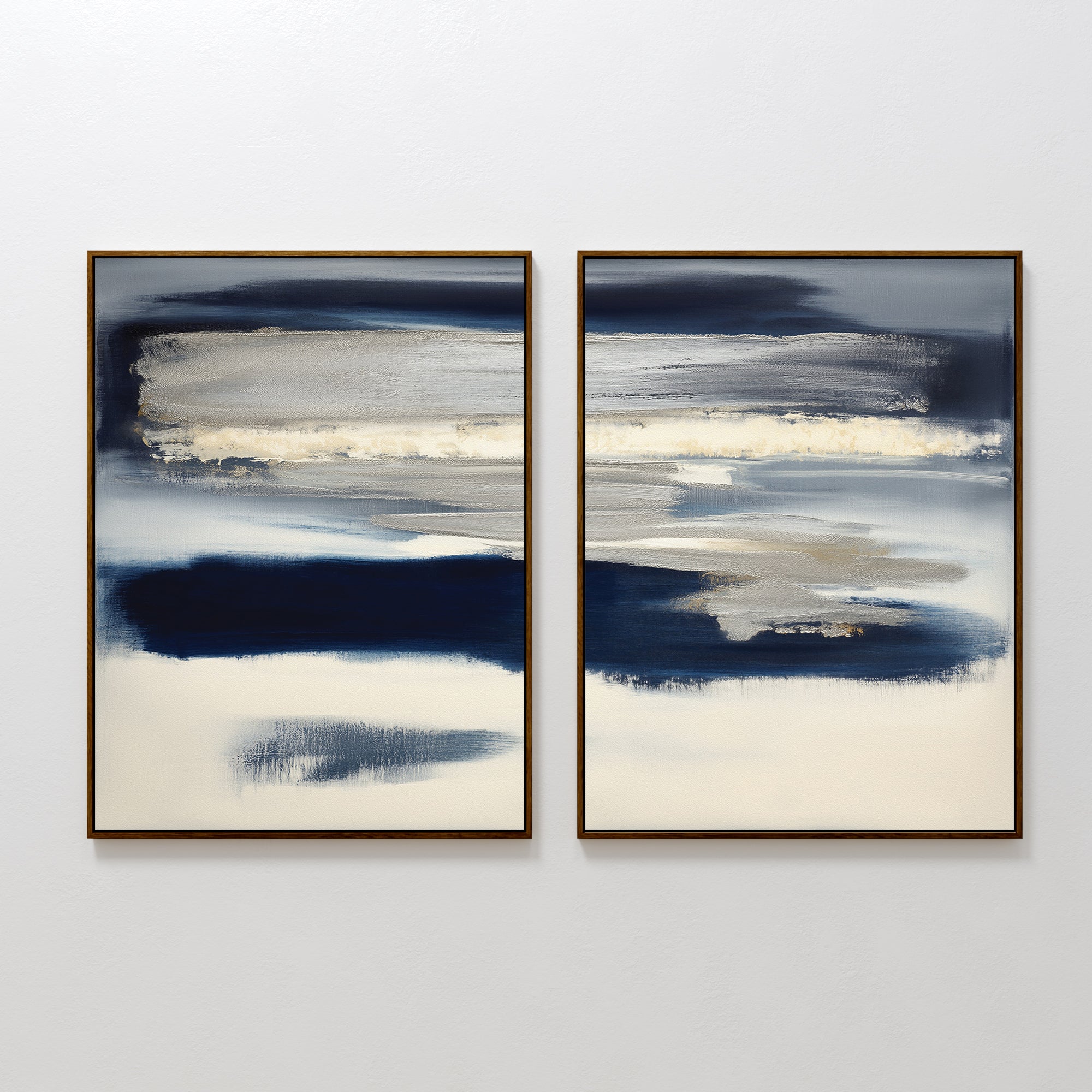 The Northern Tides - Set Of 2 features abstract prints with dark blue, beige, and white brushstrokes in slim brown frames, hung side by side on a white wall for a soft, serene, and modern look.