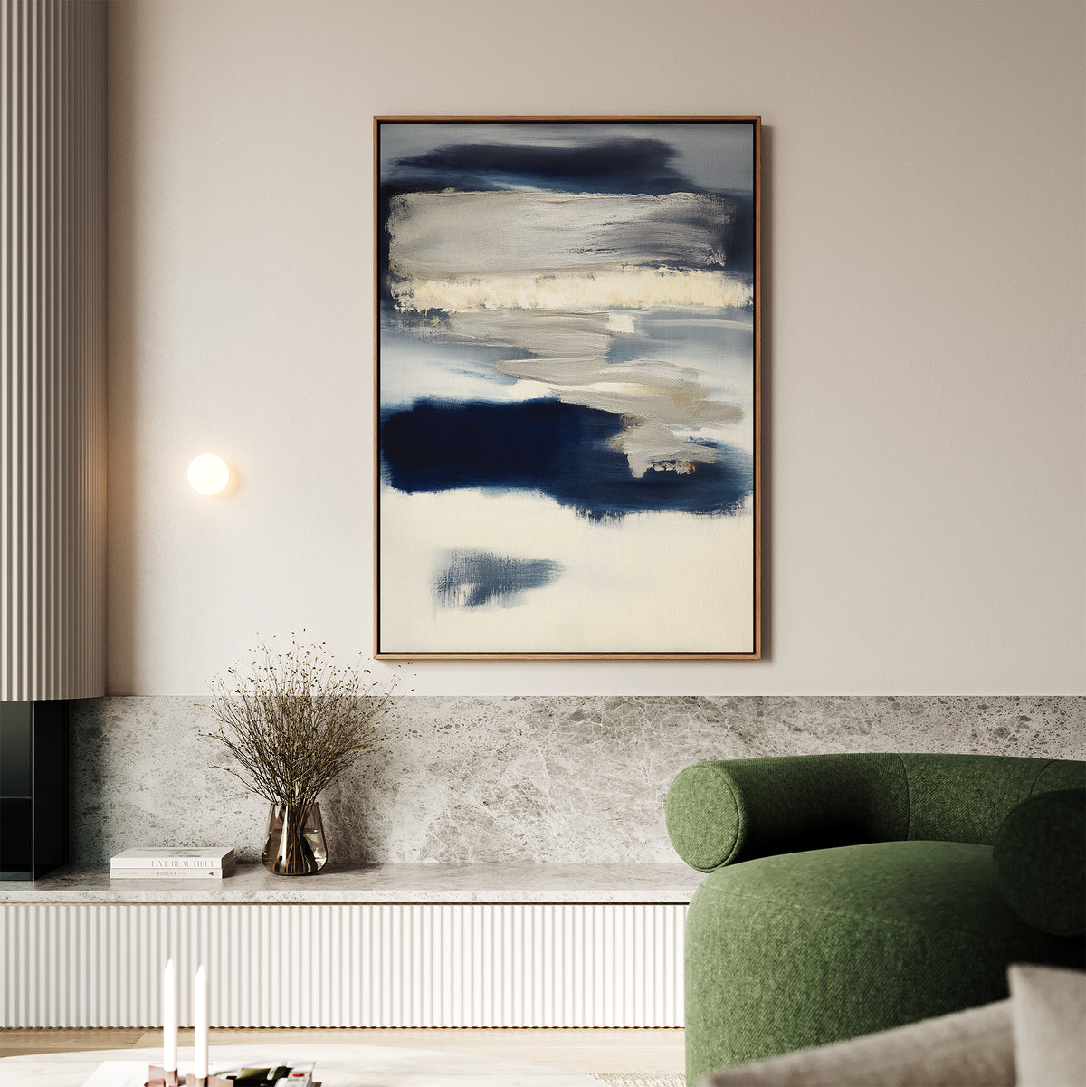 A modern living room with a green curved sofa, marble ledge, dried flower vase, and the Northern Tides Canvas Art - Vertical in blue and white above neutral-toned paneling creates a cozy minimalist space.