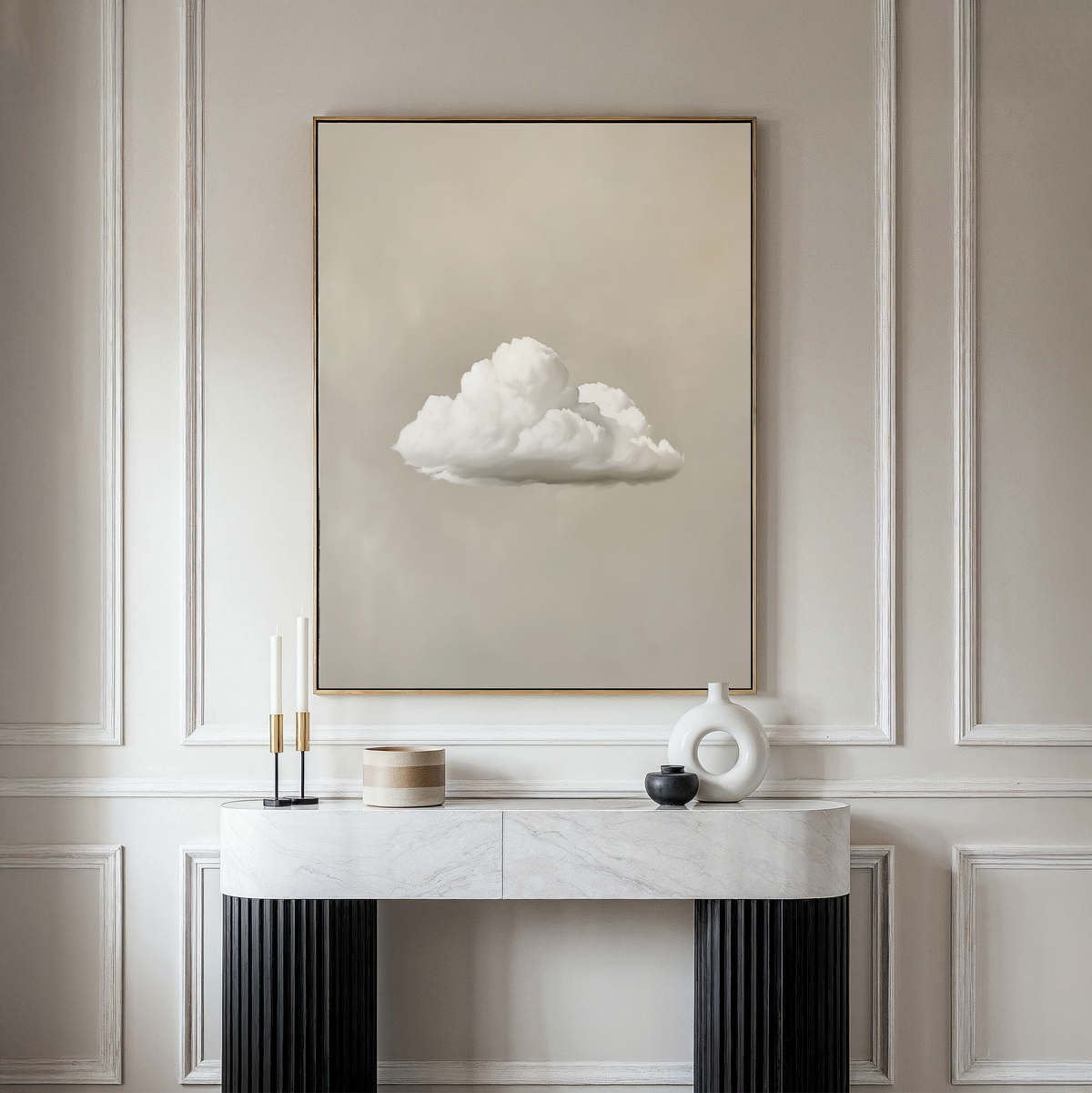 A minimalist living room features the Morning Sky Abstract Canvas Art—a framed painting of a single white cloud—on a beige wall above a white marble console table with vases and candles, creating serene decor.