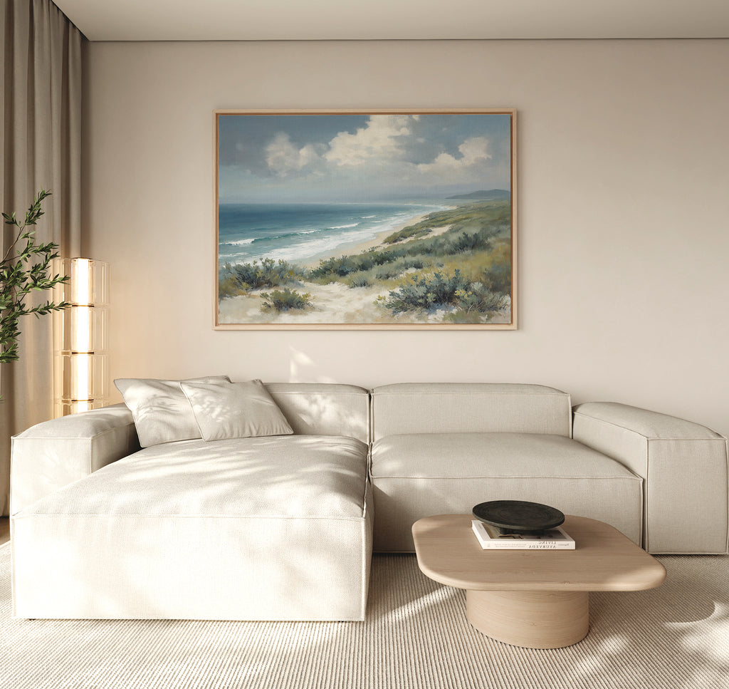A living room featuring the Ocean Bluff Canvas Art - Horizontal as a large coastal scene painting on the wall.