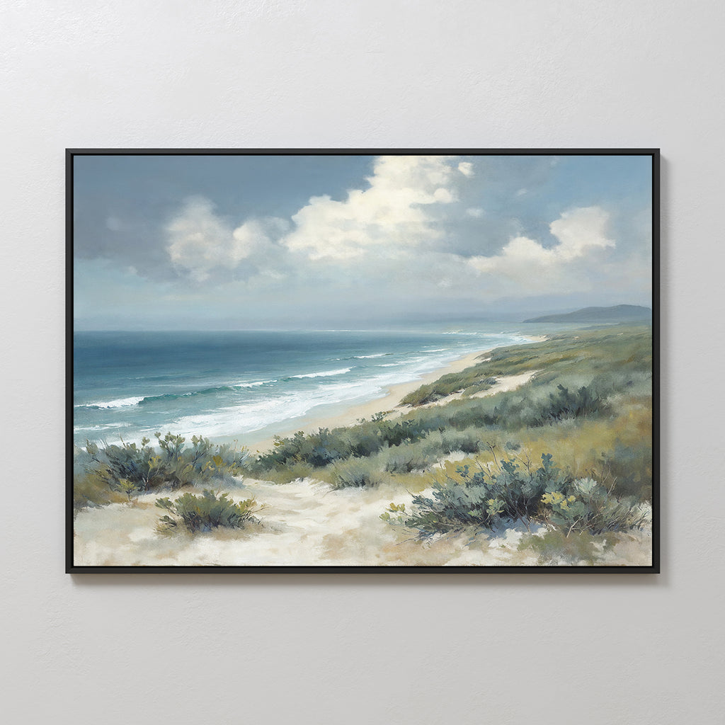 The Ocean Bluff Canvas Art - Horizontal features a coastal scene with sandy dunes, sparse vegetation, rolling waves, and a cloudy blue sky above the ocean shore in a framed canvas print.